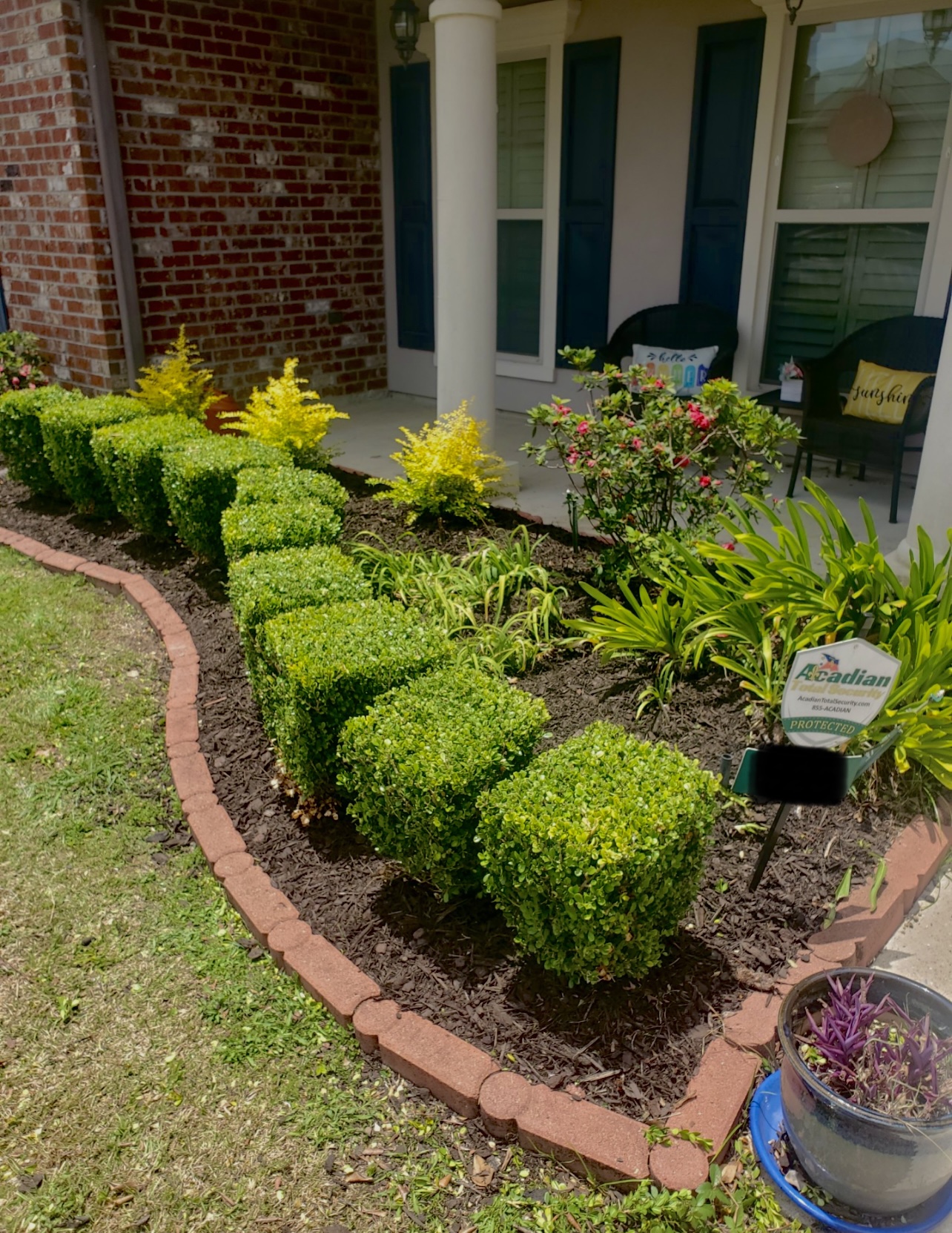 Front porch bed with trimmed shrubs and mulch